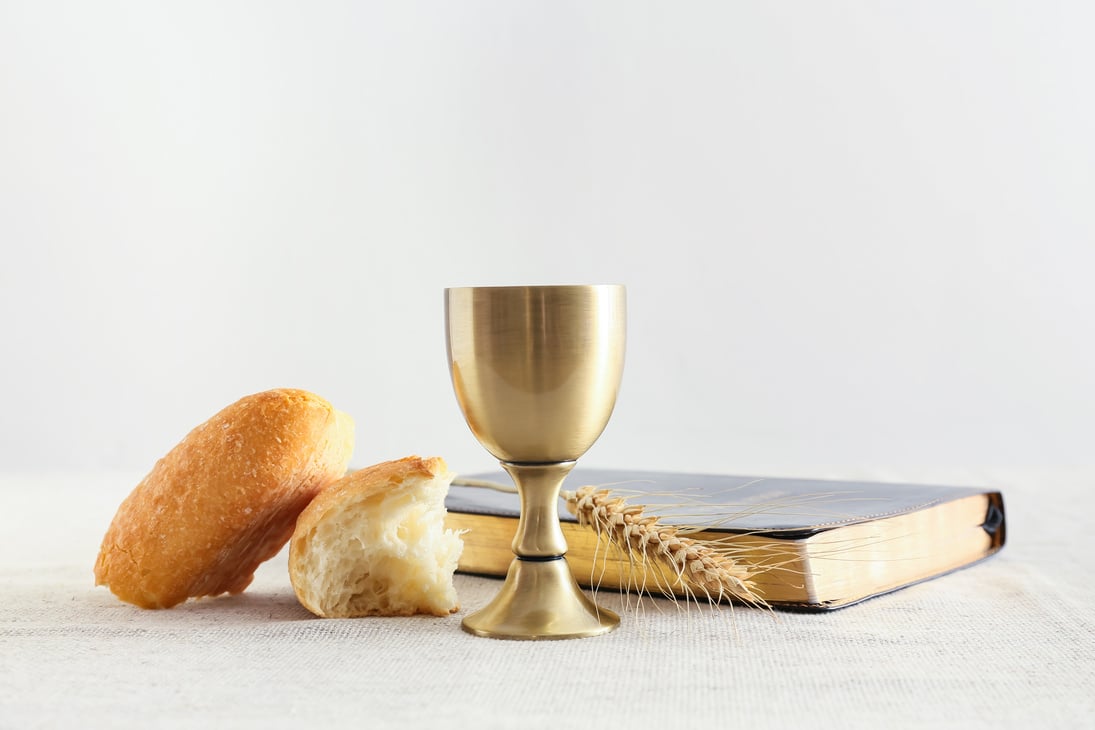 Cup of Wine with Bread and Holy Bible on Light Background